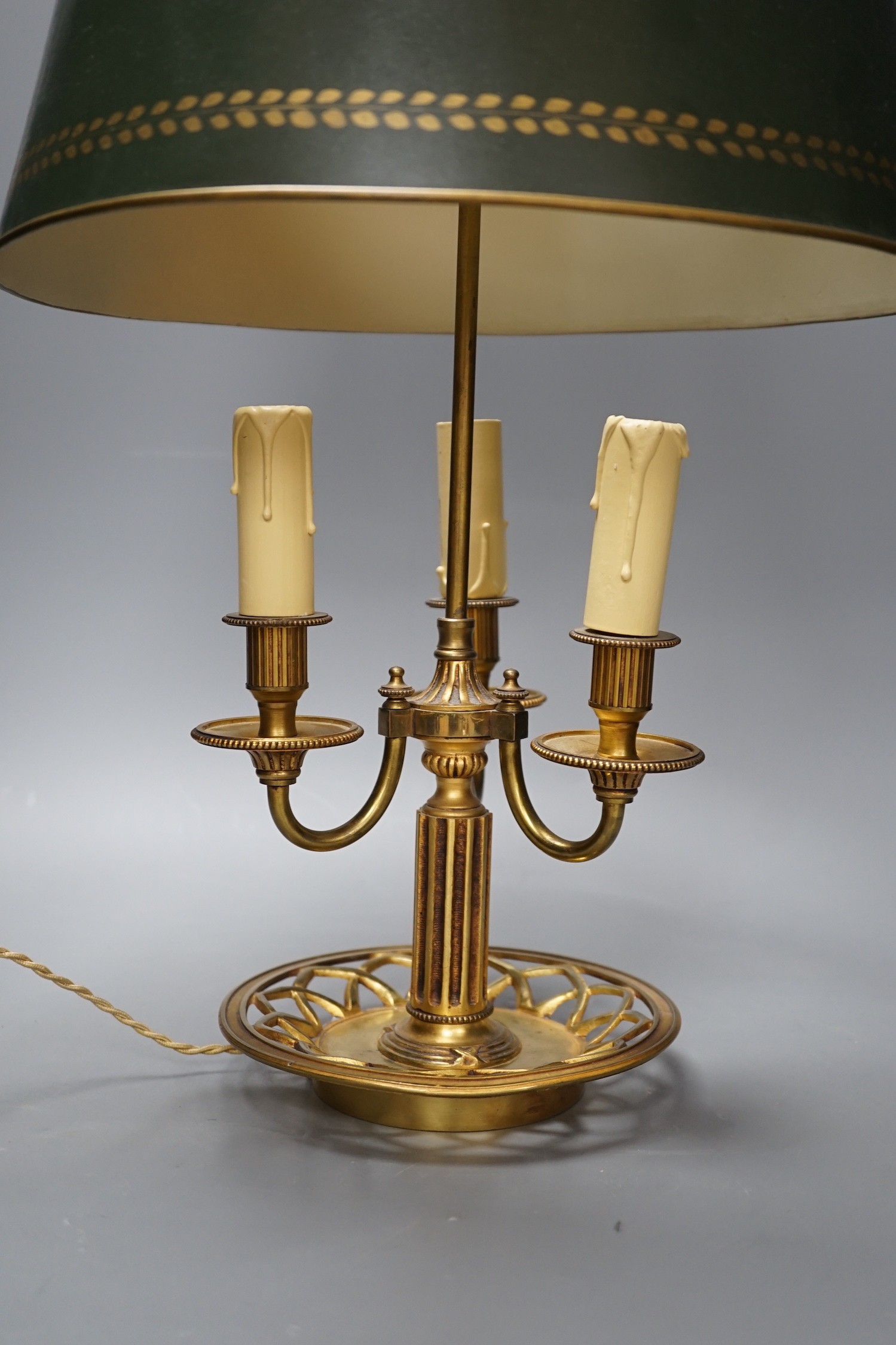 A gilt brass bouillote lamp with tole ware shade, 57 cms high